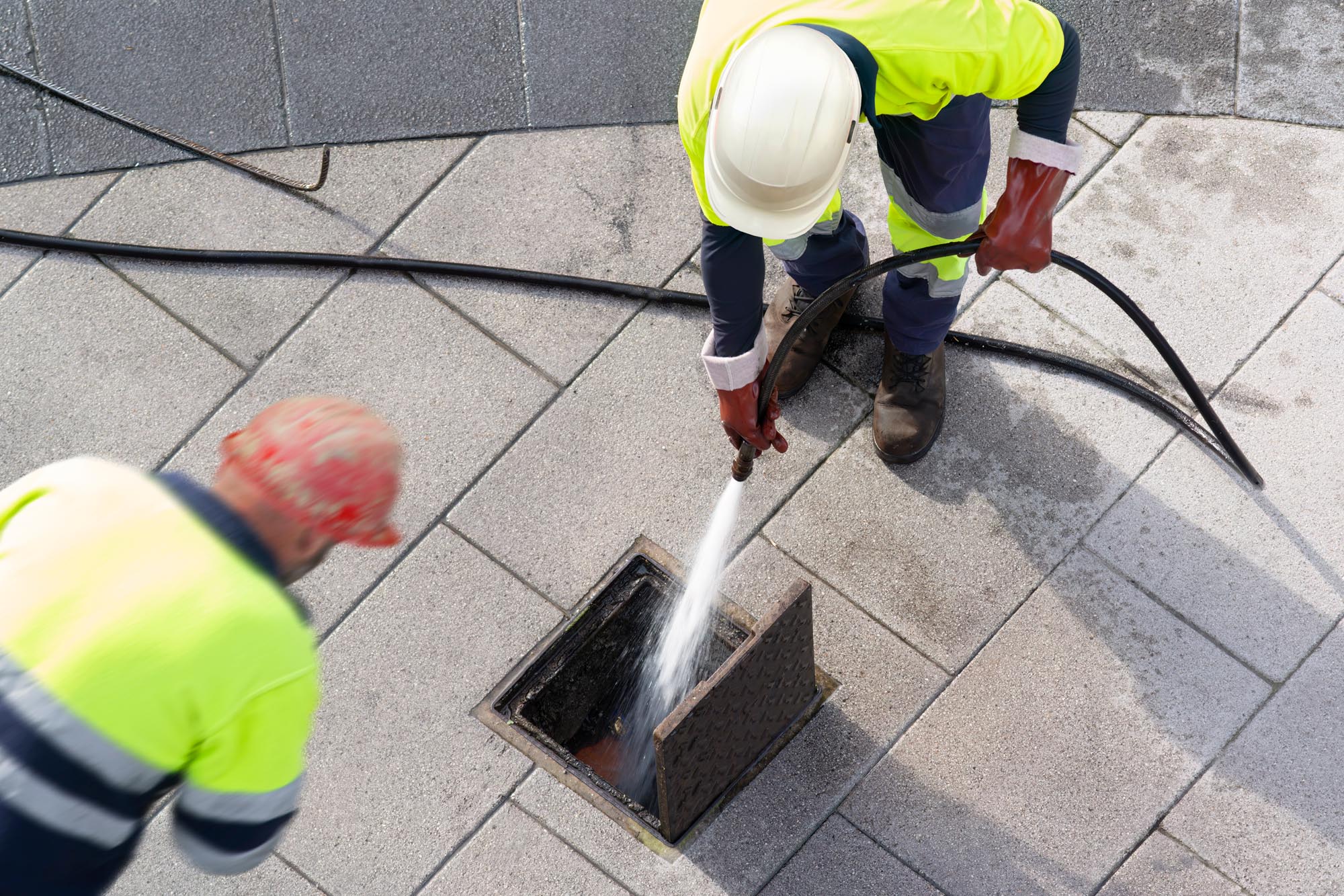 sewer workers working for cleaning with water pressure on maint