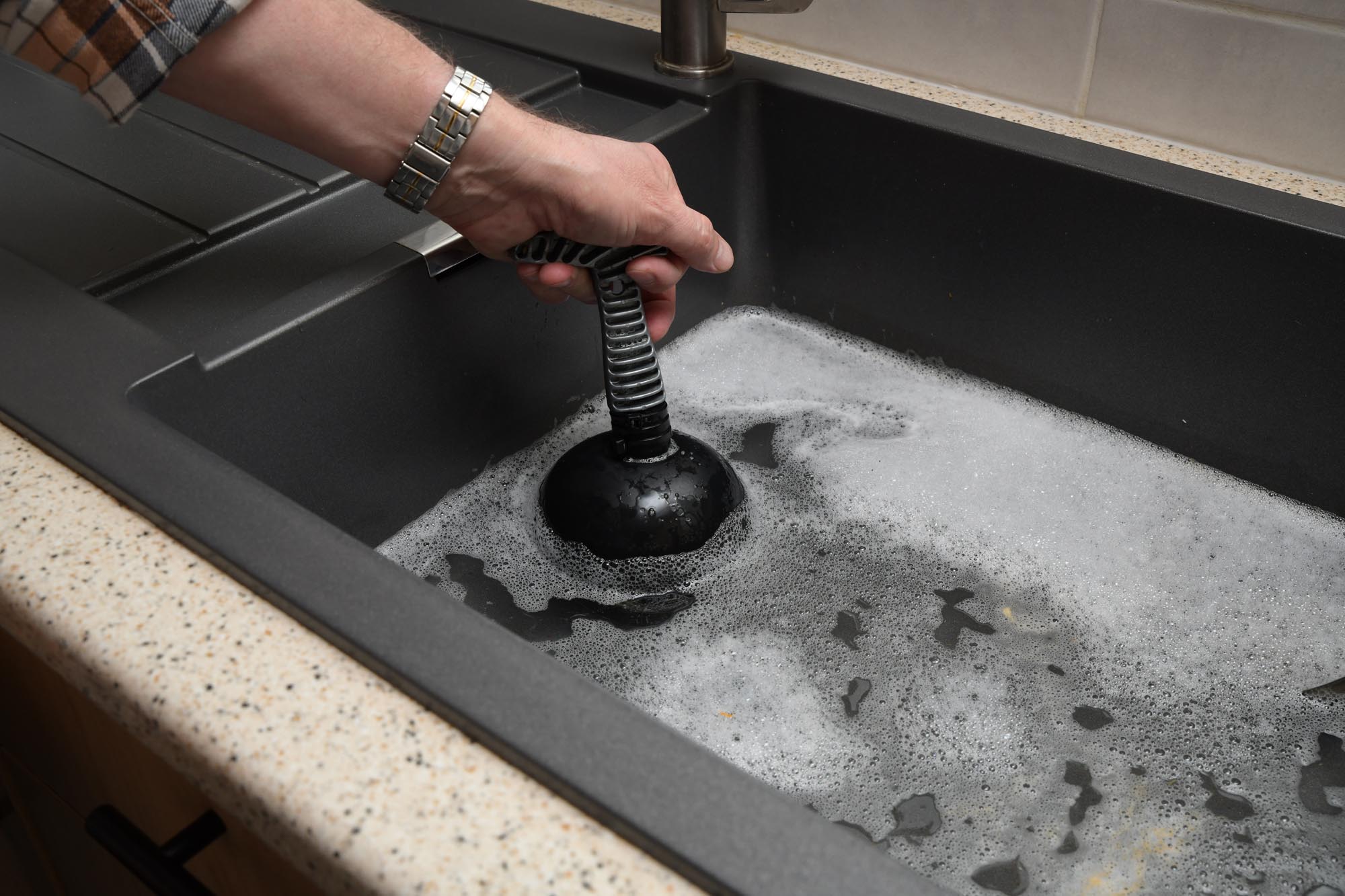 Overflowing kitchen sink, clogged drain.